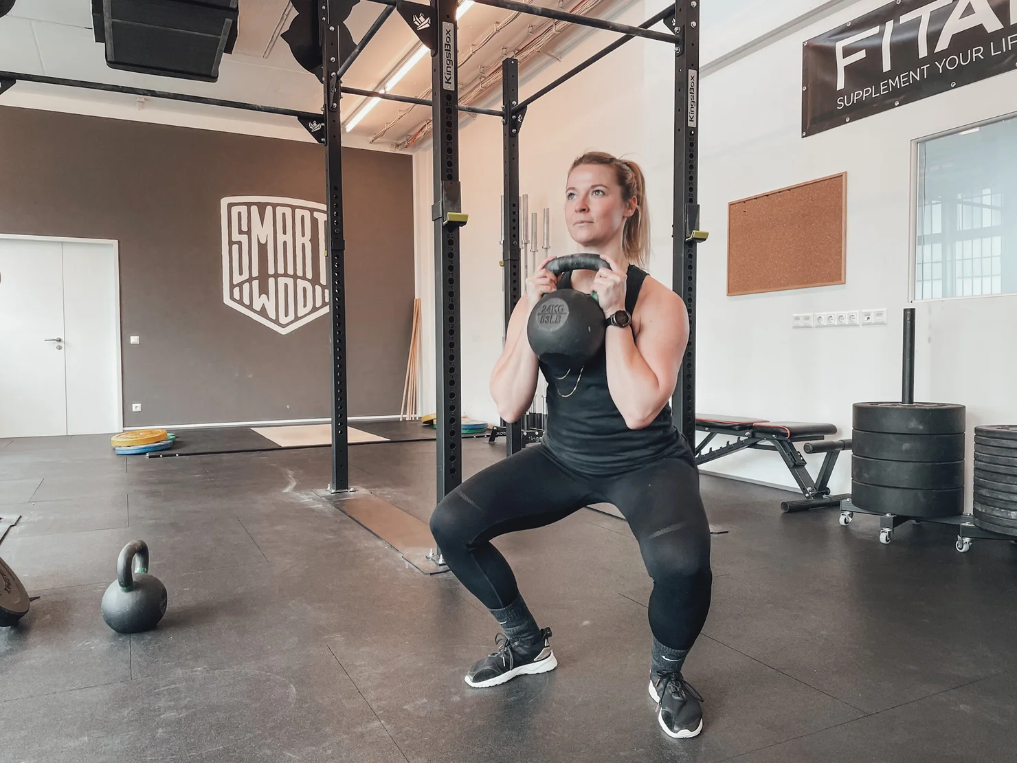 Female athlete performing a goblet squat with a kettlebell